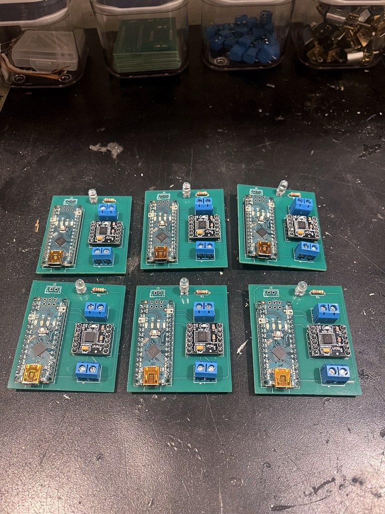 Six assembled circuit boards, each with an Arduino Nano, motor driver and LED